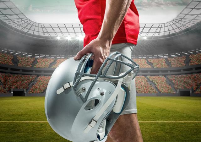 Mid section of an American football player holding helmet in stadium - Download Free Stock Photos Pikwizard.com