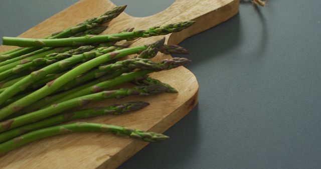 Image of asparagus on wooden chopping board over grey background - Download Free Stock Photos Pikwizard.com