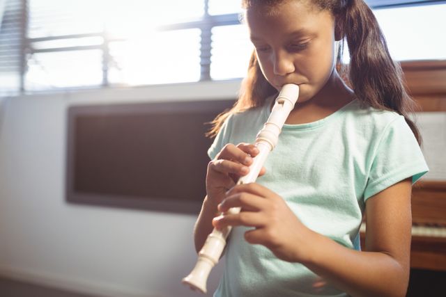 Girl practicing flute in class - Download Free Stock Photos Pikwizard.com