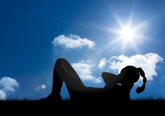 Silhouette of woman practicing yoga on grass against blue sky in background