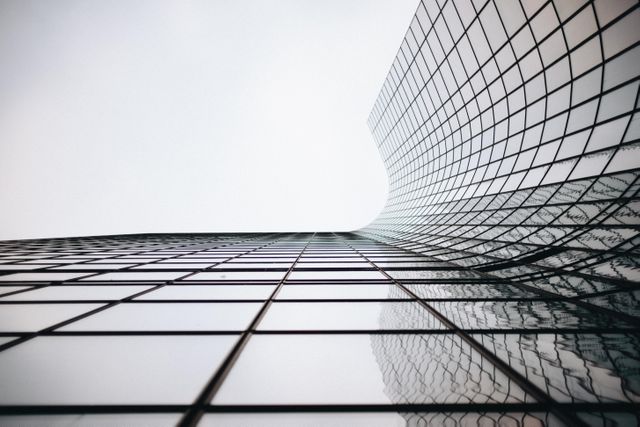 Low angle view of generic modern office skyscrapers with abstract geometry glass facades. Business and future architecture concept