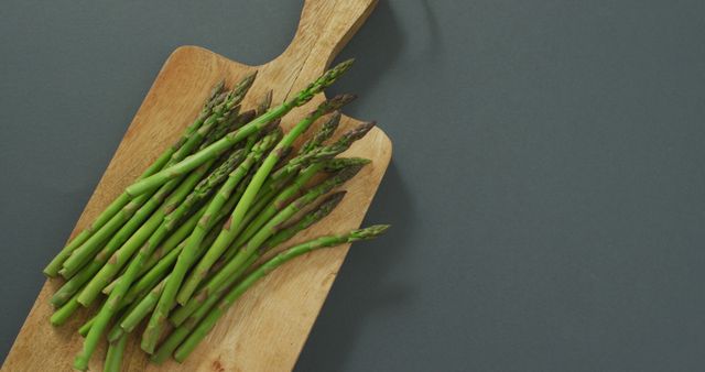 Image of asparagus on wooden chopping board over grey background - Download Free Stock Photos Pikwizard.com