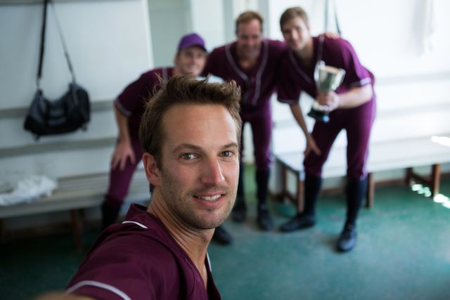 Portrait of smiling baseball team clicking selfie while standing at locker room - Download Free Stock Photos Pikwizard.com