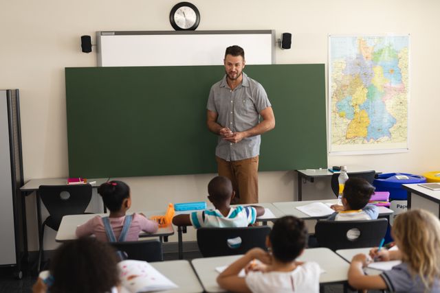 Male teacher teaching in classroom of elementary school - Download Free Stock Photos Pikwizard.com