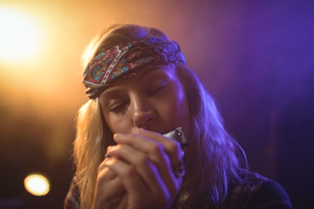 Beautiful female musician playing harmonica in nightclub - Download Free Stock Photos Pikwizard.com