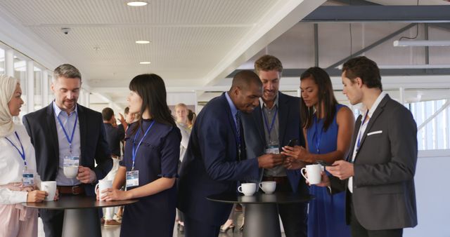 Front view of a diverse group of business delegates talking and drinking coffee during a break at a business conference