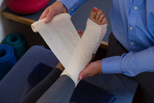 Physiotherapist putting bandage on injured feet of patient - Download Free Stock Photos Pikwizard.com