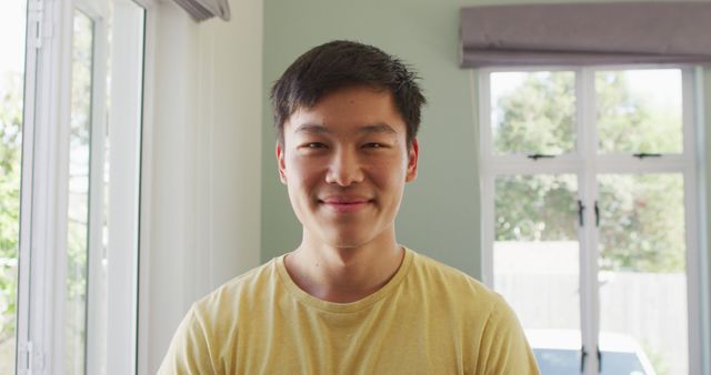 Portrait of happy asian man smiling in living room - Download Free Stock Photos Pikwizard.com