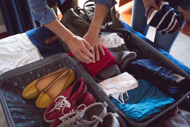 Mid section of caucasian couple packing their bags together at home - Download Free Stock Photos Pikwizard.com