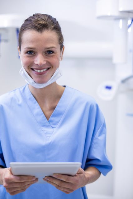 Smiling dental assistant holding digital tablet - Download Free Stock Photos Pikwizard.com