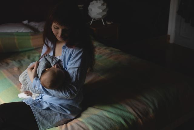 Mother breast feeding her baby in bedroom - Download Free Stock Photos Pikwizard.com
