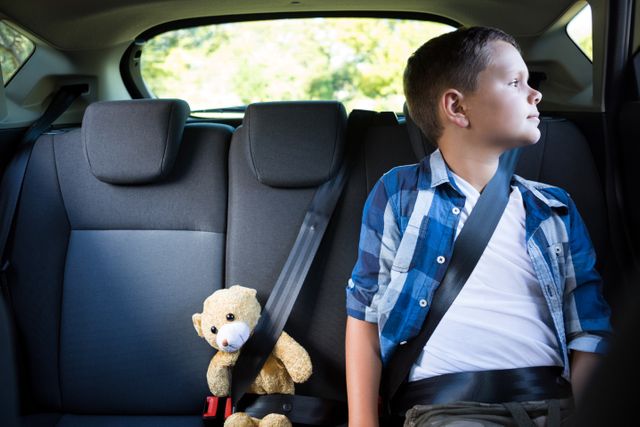 Teenage boy sitting with teddy bear in the car - Download Free Stock Photos Pikwizard.com
