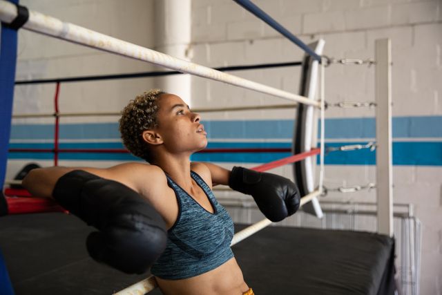 Mixed race woman resting after training in boxing ring - Download Free Stock Photos Pikwizard.com