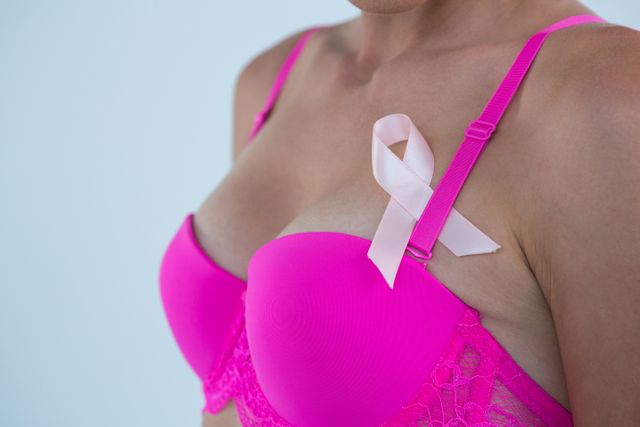 Mid section of woman in pink bra with Breast Cancer Awareness ribbon - Download Free Stock Photos Pikwizard.com