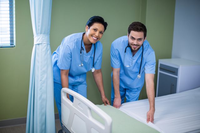 Portrait of male and female nurse preparing bed for patient - Download Free Stock Photos Pikwizard.com