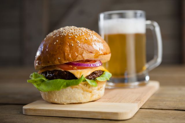 Burger with glass of beer on chopping board - Download Free Stock Photos Pikwizard.com