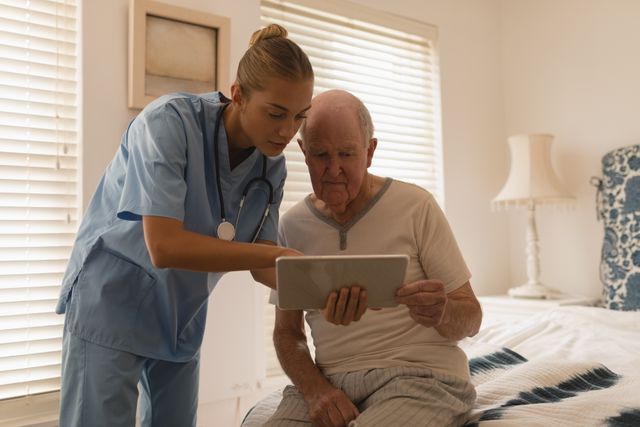 Female doctor and senior man using digital tablet - Download Free Stock Photos Pikwizard.com
