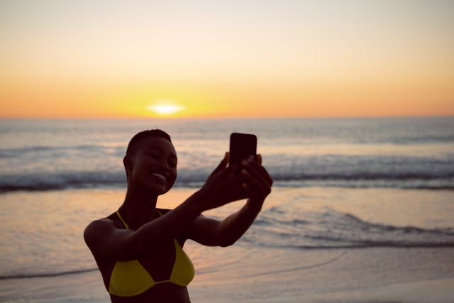 Woman in bikini taking selfie with mobile phone on the beach - Download Free Stock Photos Pikwizard.com