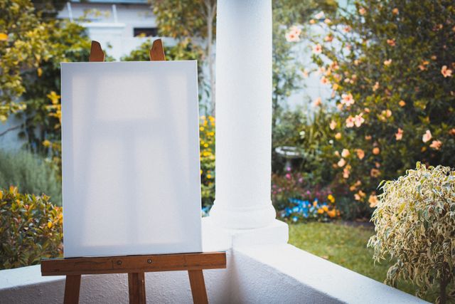 Blank painting canvas sitting on easel on terrace in summer garden - Download Free Stock Photos Pikwizard.com