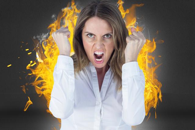 Digital composite image of angry businesswoman clenching fists against fire - Download Free Stock Photos Pikwizard.com