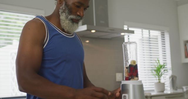 Image of african american senior man preparing smoothie. retirement lifestyle, spending time alone at home concept digitally generated image.