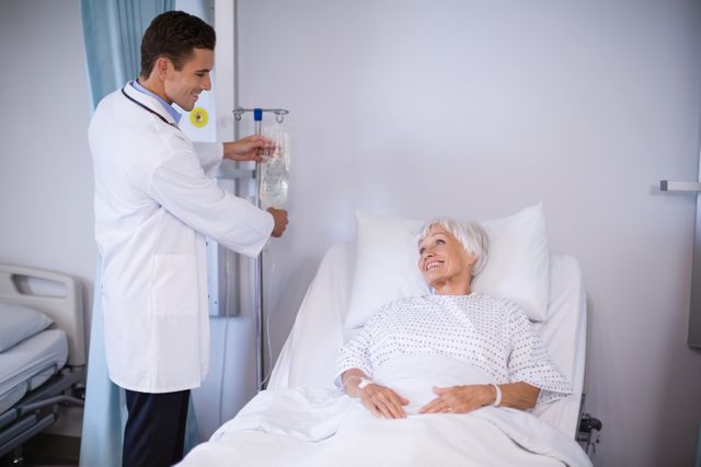 Doctor adjusting iv drip while patient lying on bed - Download Free Stock Photos Pikwizard.com