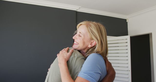 Mixed race senior couple hugging each other at home - Download Free Stock Photos Pikwizard.com