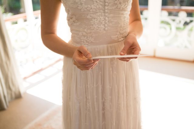 Midsection of bride holding wedding card at home - Download Free Stock Photos Pikwizard.com