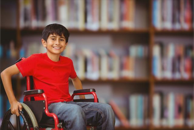 Digital composite of Happy boy in wheelchair against blurred background
