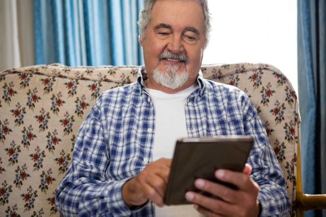 Smiling senior man using digital tablet in nursing home - Download Free Stock Photos Pikwizard.com