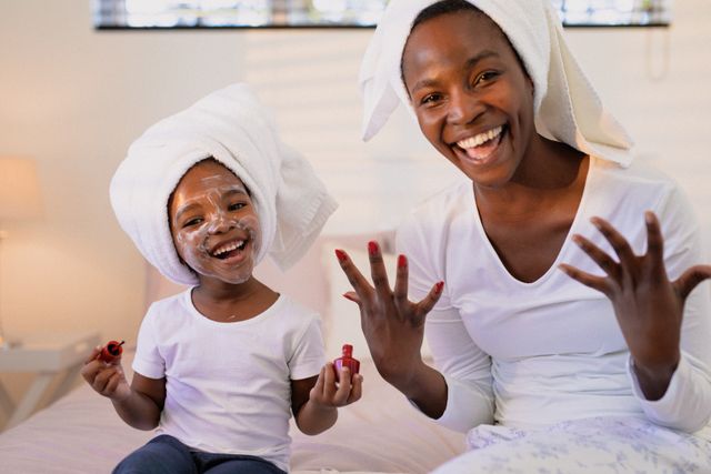 Happy african american mother and daughter wearing turbans, painting nails - Download Free Stock Photos Pikwizard.com