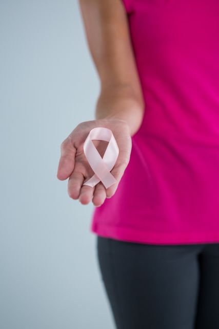 Mid section of female holding pink ribbon - Download Free Stock Photos Pikwizard.com