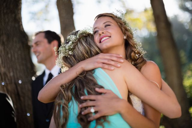Bride embracing her friend in park - Download Free Stock Photos Pikwizard.com