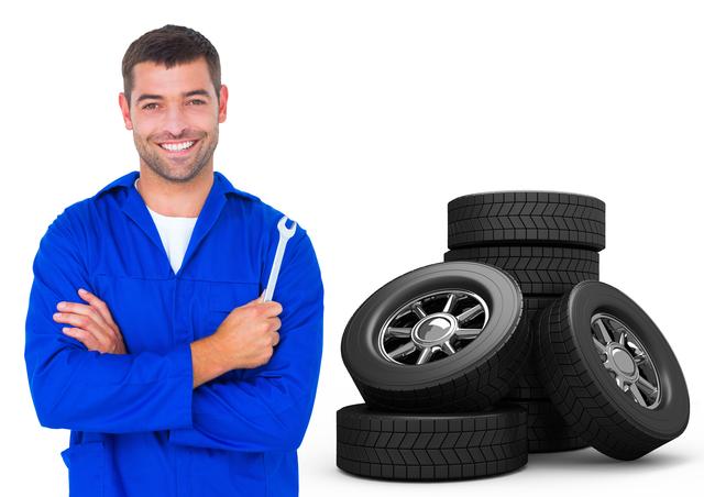 Mechanic holding wrench against tyres in background - Download Free Stock Photos Pikwizard.com