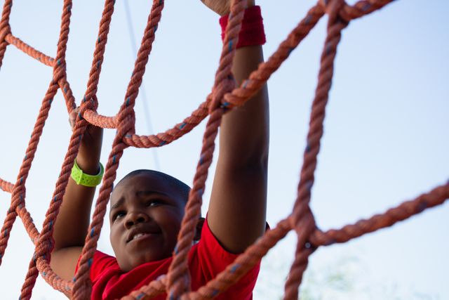 Boy climbing a net during obstacle course training - Download Free Stock Photos Pikwizard.com