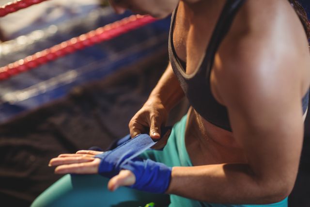 Female boxer wearing blue strap on wrist in boxing ring