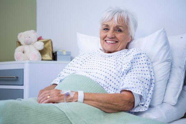 Portrait of smiling senior patient on bed - Download Free Stock Photos Pikwizard.com