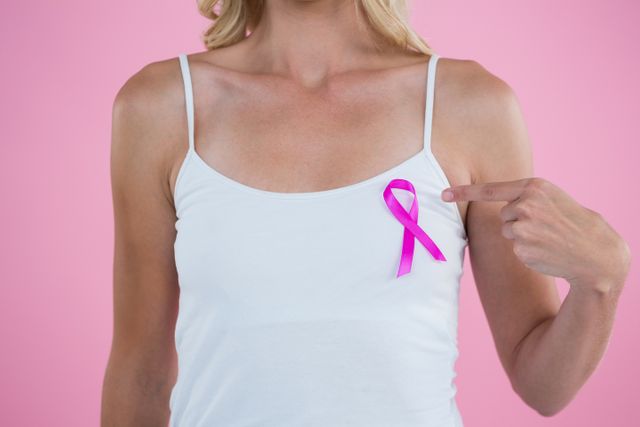 Mid section of woman pointing on Breast Cancer Awareness ribbon - Download Free Stock Photos Pikwizard.com