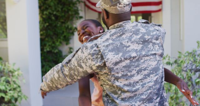 African american male soldier hugging smiling wife in front of house with american flag - Download Free Stock Photos Pikwizard.com