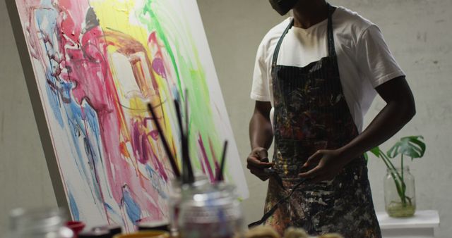 African american male artist wearing face mask tying his apron at art studio - Download Free Stock Photos Pikwizard.com
