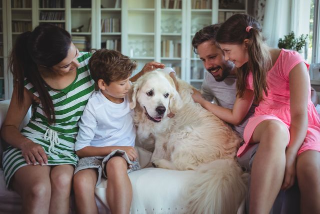 Family sitting on sofa with pet dog in living room - Download Free Stock Photos Pikwizard.com
