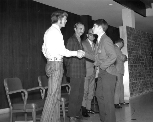 Silverton, Oregon high school student, Daniel C. Bochsler, is greeted by (left to right): Astronauts Russell L. Schweickart, and Owen K. Garriott; Marshall Space Flight Center (MSFC) Skylab Program Manager, Leland Belew; and MSFC Director of Administration and Technical Services, David Newby, during a tour of MSFC. Bochsler  was among 25 winners of a contest in which some 3,500 high school students proposed experiments for the following year’s Skylab mission. The nationwide scientific competition was sponsored by the National Science Teachers Association and the National Aeronautics and Space Administration (NASA). The winning students, along with their parents and sponsor teachers, visited MSFC where they met with scientists and engineers, participated in design reviews for their experiments, and toured MSFC facilities. Of the 25 students, 6 did not see their experiments conducted on Skylab because the experiments were not compatible with Skylab hardware and timelines. Of the 19 remaining, 11 experiments required the manufacture of additional equipment. 