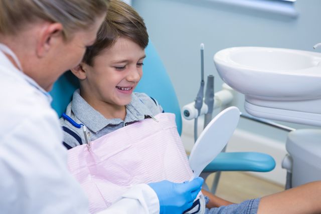Dentist showing mirrior to boy - Download Free Stock Photos Pikwizard.com