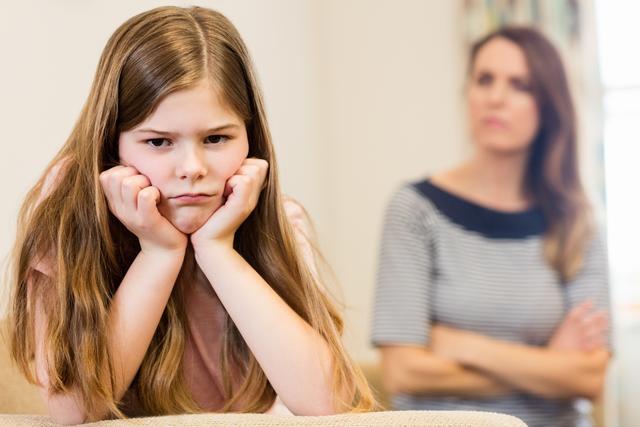 Daughter sitting upset with her mother in living room - Download Free Stock Photos Pikwizard.com