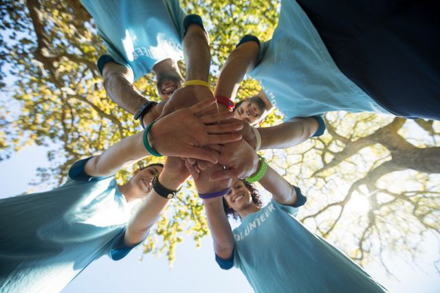 Volunteers forming a hand stack in the park - Download Free Stock Photos Pikwizard.com