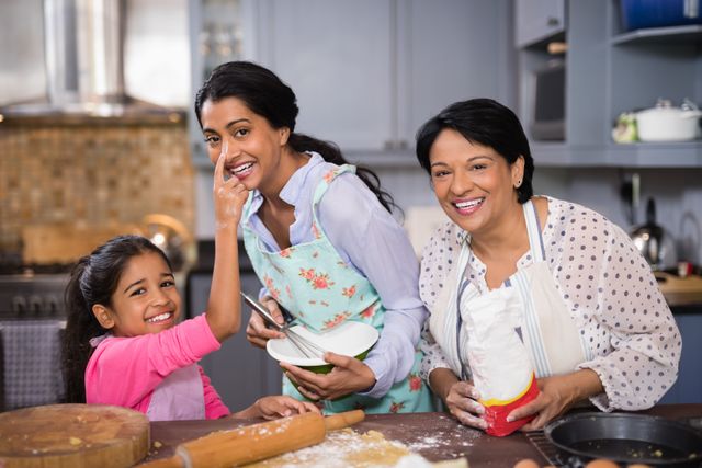 Portrait of cheerful multi-generation family preparing food together in kitchen at home