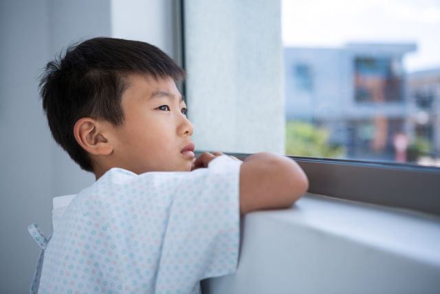 Boy patient looking out from the window at hospital - Download Free Stock Photos Pikwizard.com