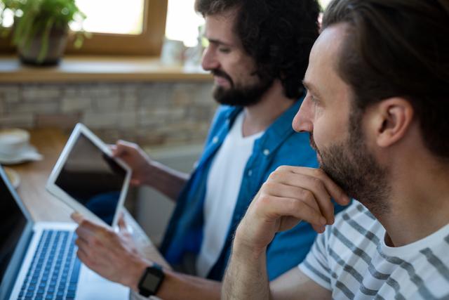 Two men looking at digital tablet - Download Free Stock Photos Pikwizard.com