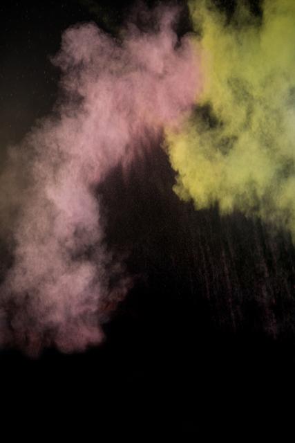 Splashing of color powder on black background