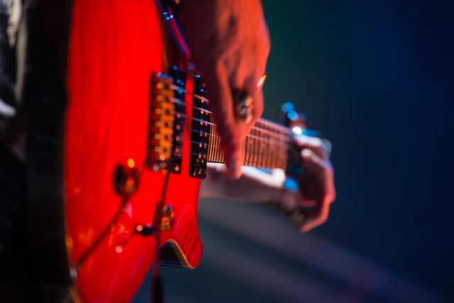 Close-up of guitarist playing guitar on stage - Download Free Stock Photos Pikwizard.com